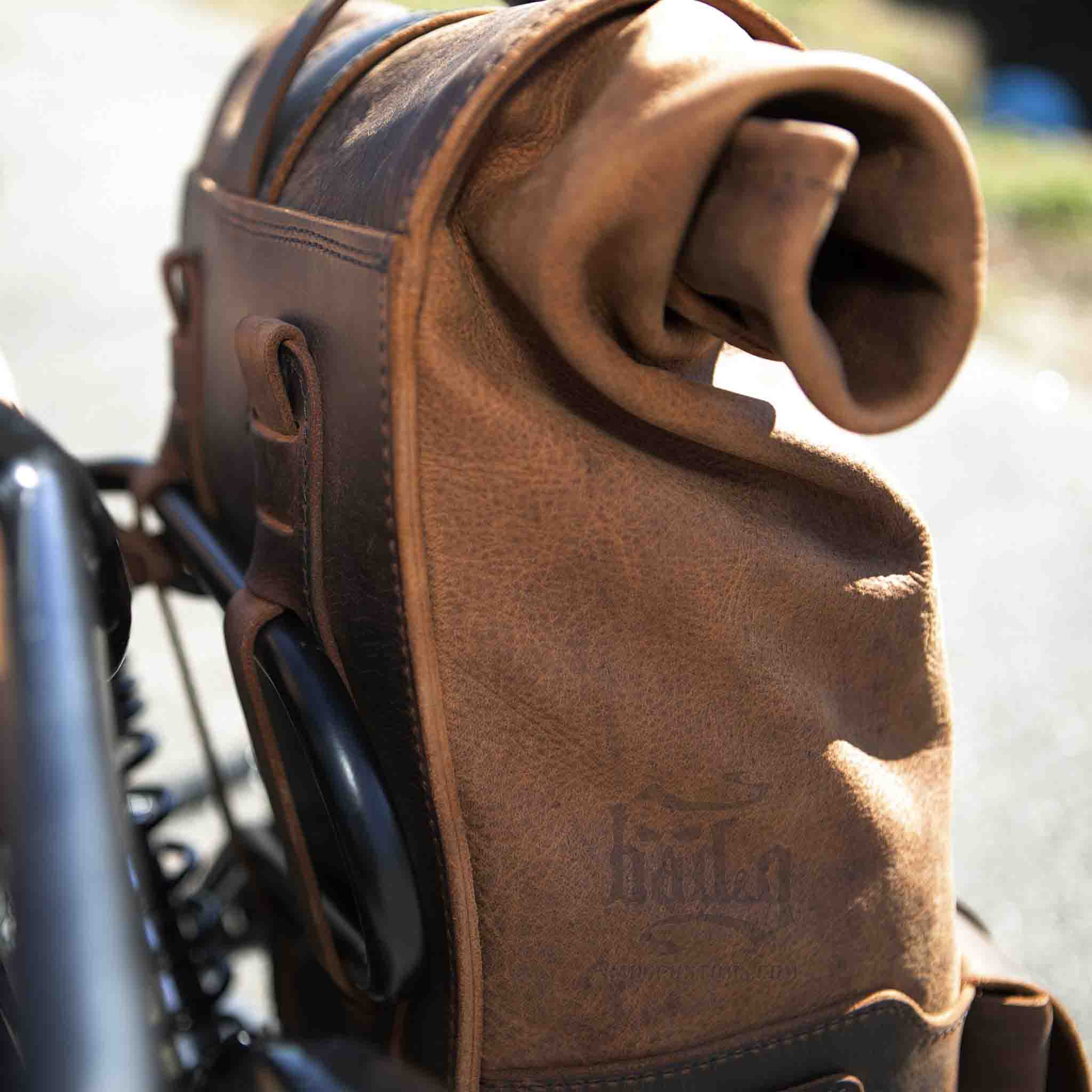 Upgrade your ride with the URB01 Rolltop Backpack Saddlebag. Unique design enables quick conversion from saddlebag to backpack. Hand crafted in USA with premium veg tan water buffalo leather and stainless steel hardware. Durable and stylish, it's the perfect fit for your motorcycle.
